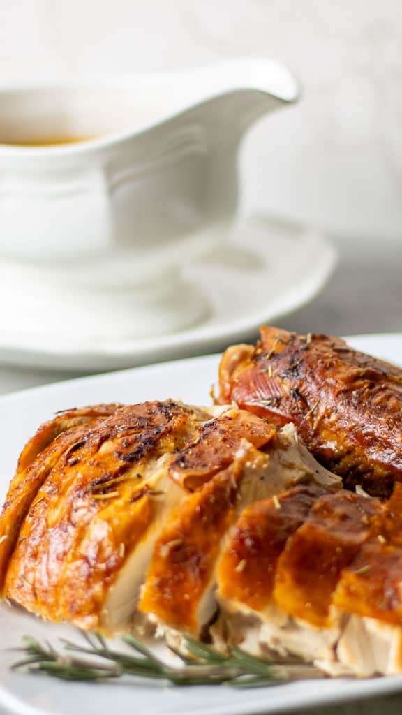 roasted pasture raised turkey on a plate with a gravy dish