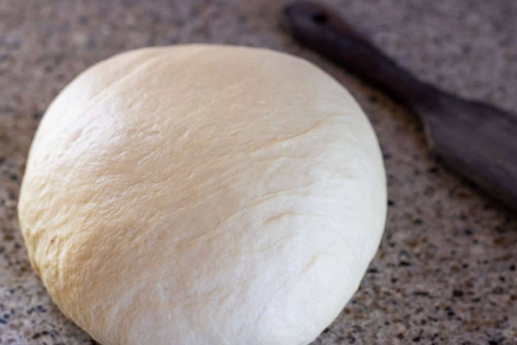 A smooth ball of dinner roll dough.