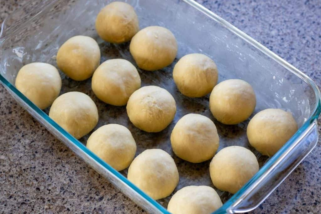 A baking dish filled with sourdough discard dough balls for dinner rolls.