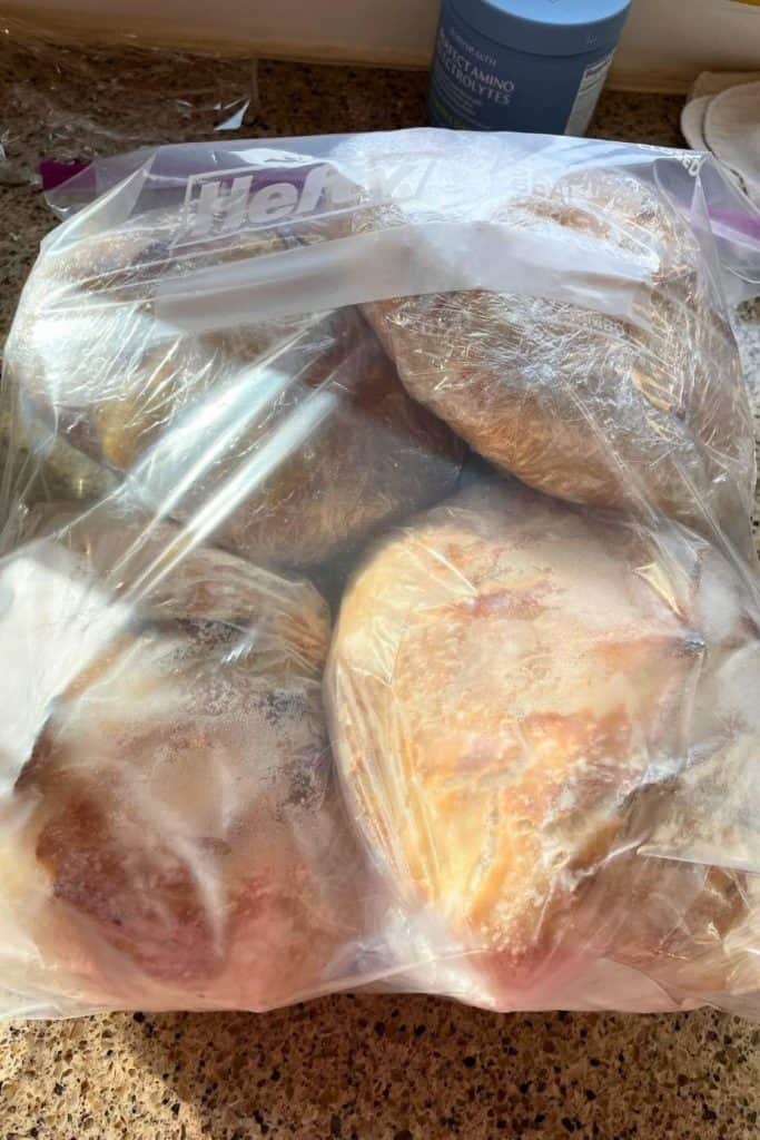 Four loaves of sourdough bread wrapped individually and placed in an extra large plastic storage bag.