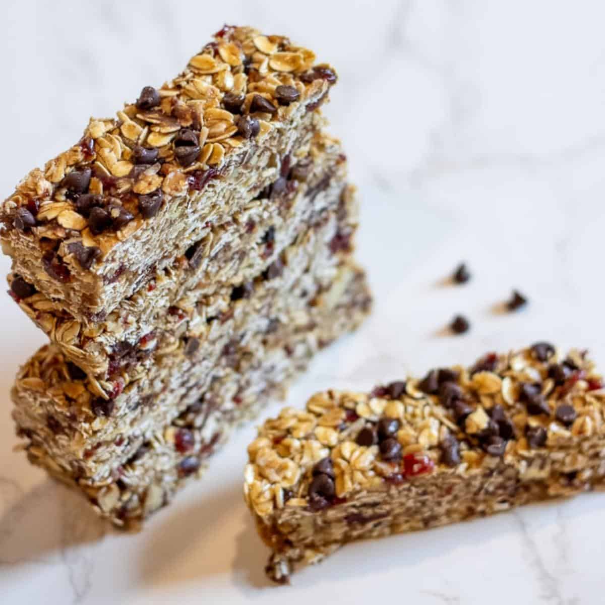 A stack of sourdough granola bars with a few chocolate chips sprinkled beside.