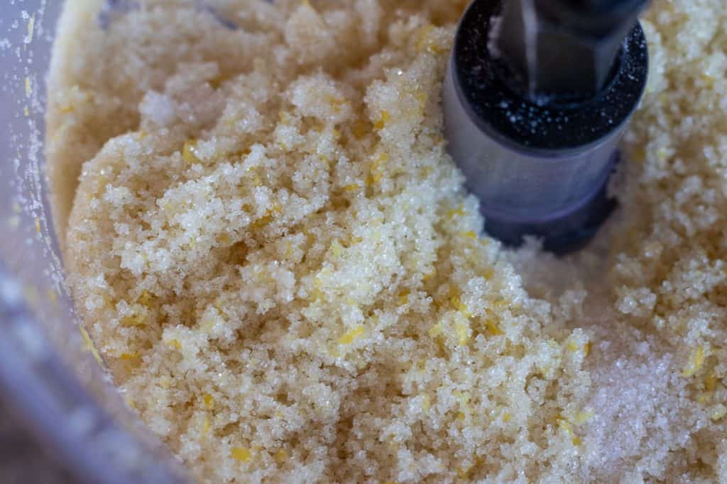 A mixture of sugar and lemon zest in a food processor.