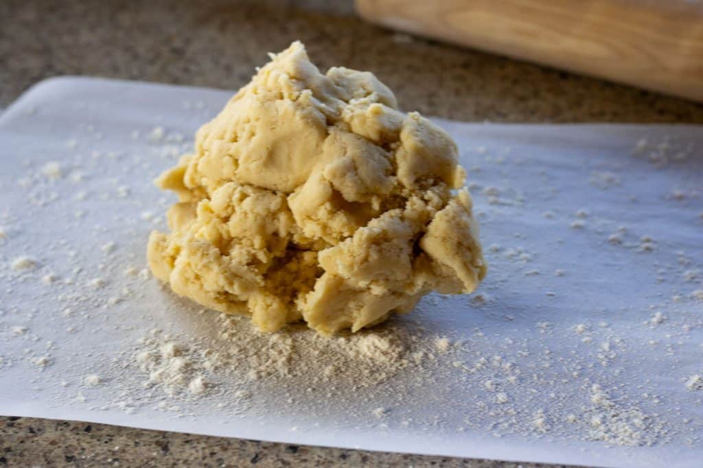 Sourdough lemon shortbread dough on a lightly floured piece of parchment paper.
