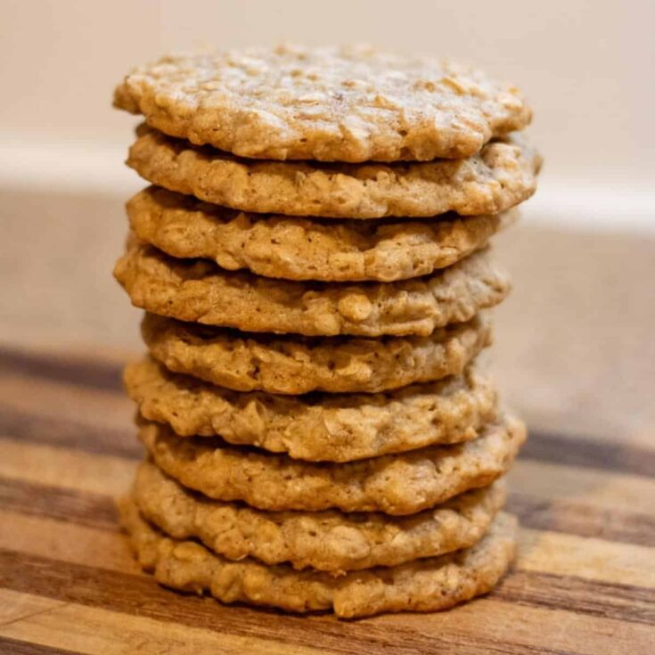 A stack of sourdough oatmeal cookies on a cutting board.