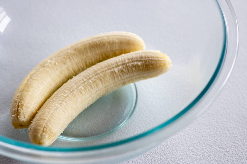 A bowl with two overripe bananas in it.