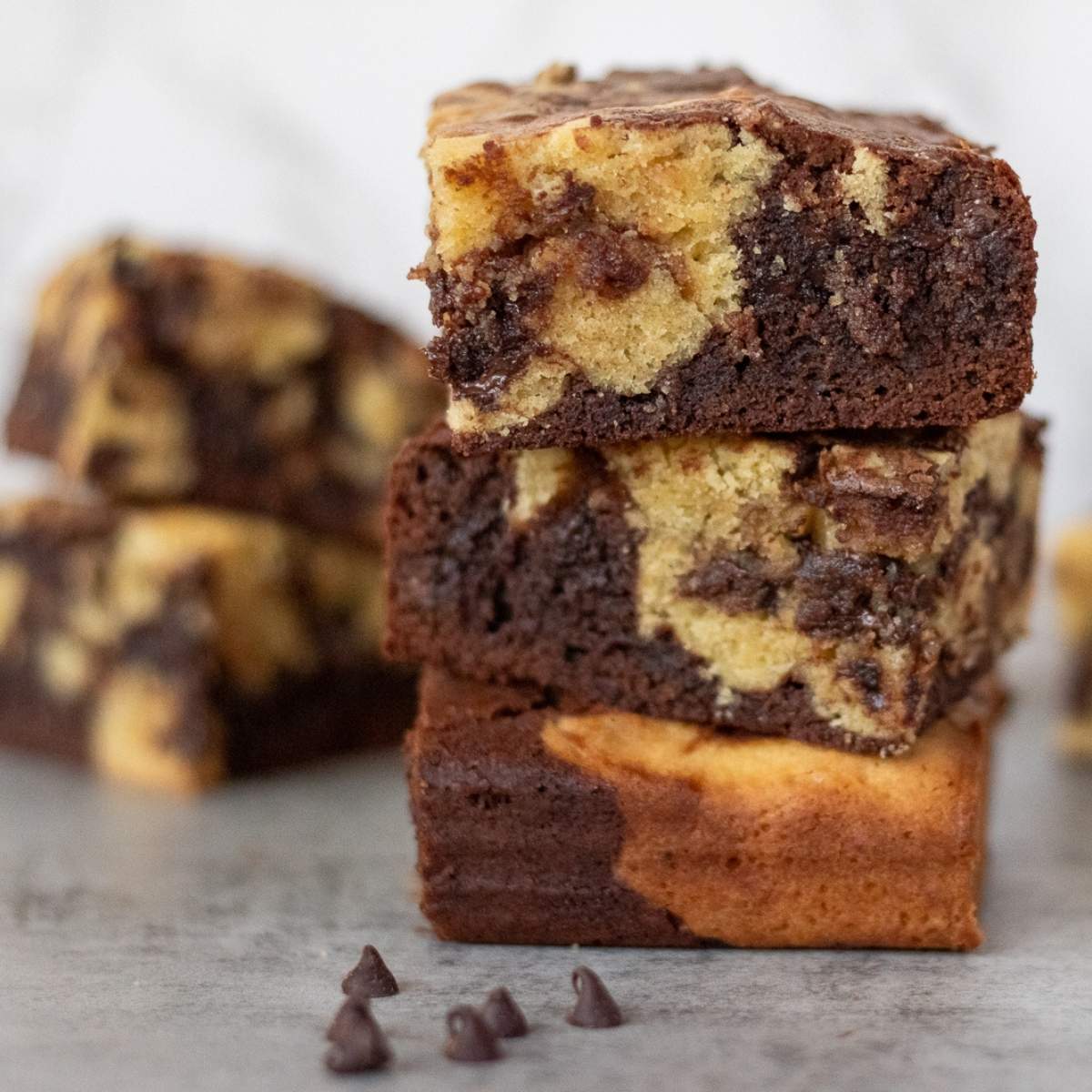 A stack of three sourdough brookies which are a combination discard brownie and chocolate chip cookie bar.