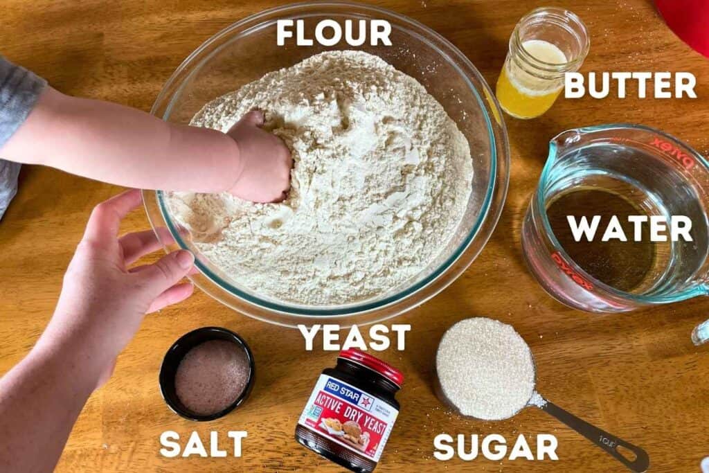 All the ingredients laid out on a table for making a white sandwich bread recipe.