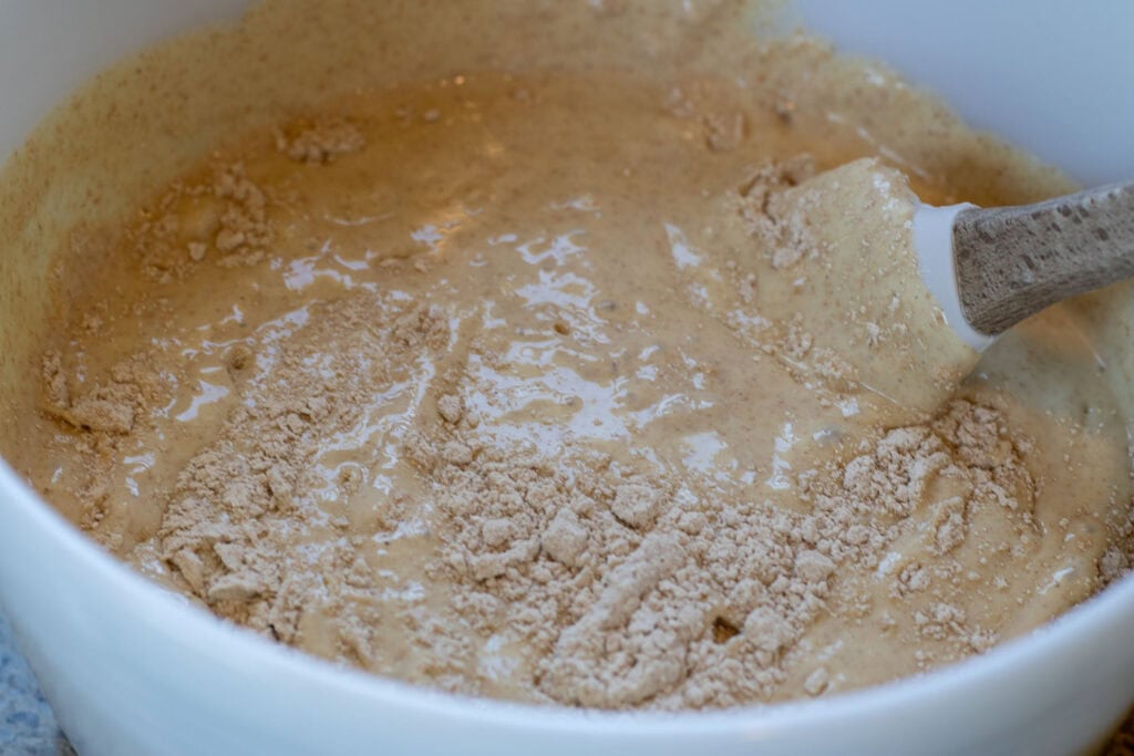 Partially mixed pancake batter with dry flour still visible.