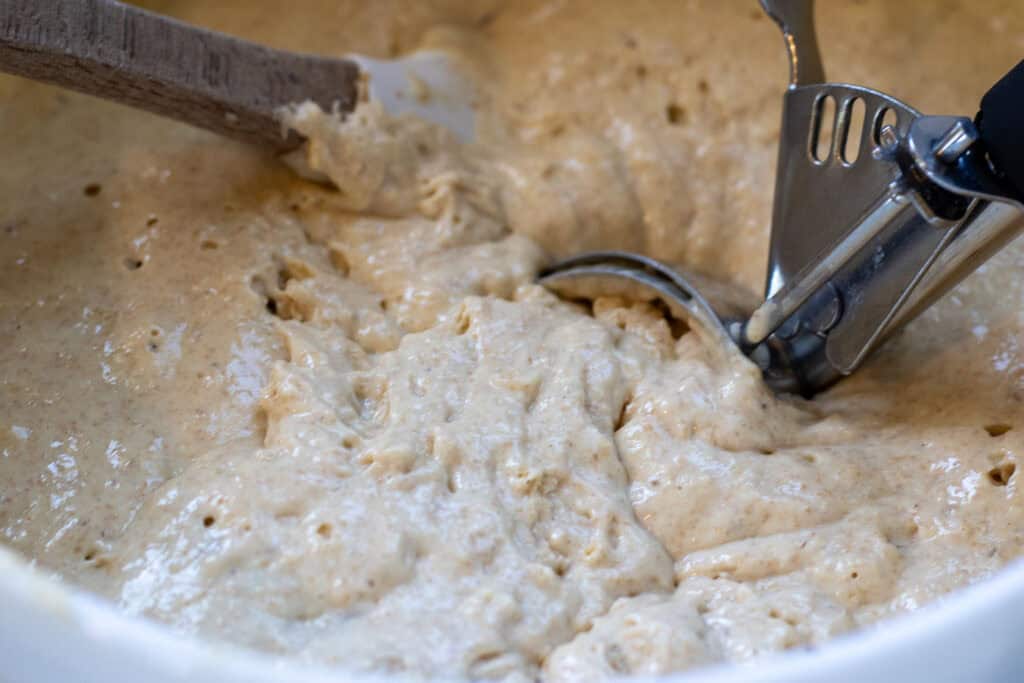 Thick pancake batter being portioned with a cookie scoop.